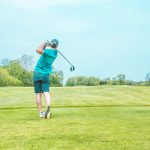 man positioned in golf swing