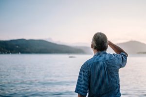 Elderly man looking out over the ocean view