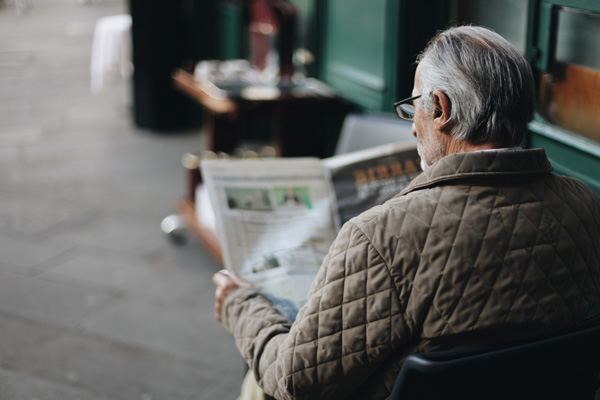 Elderly man reading newspaper