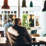 Elderly man sat in a cafe with a coffee