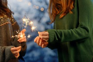 girls playing with sparklers at a distance for eye safety