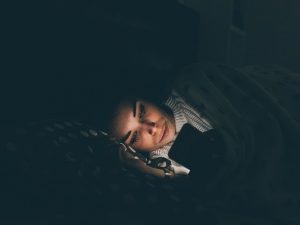 Women using her phone before bed in the dark